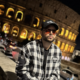 Danny Eviza sitting on a wall with a laptop in front of the illuminated Colosseum at night