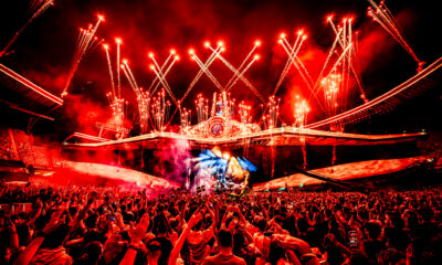 Red fireworks and pyrotechnics exploding above the UNTOLD Mainstage as the crowd raises their hands and phones