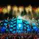Crowd filming fireworks above a blue-lit stage at EDC Thailand in Phuket