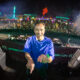 DJ Isaac smiling and pointing at the camera on the Basscon stage at EDC with a packed crowd behind him