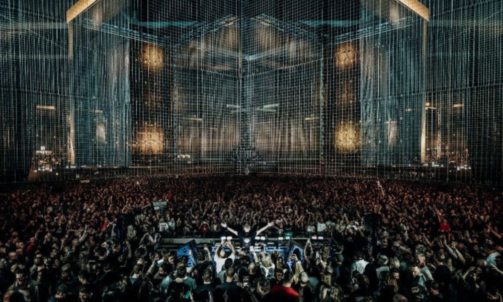 Armin van Buuren performing in front of a large crowd beneath the stage production at A State of Trance