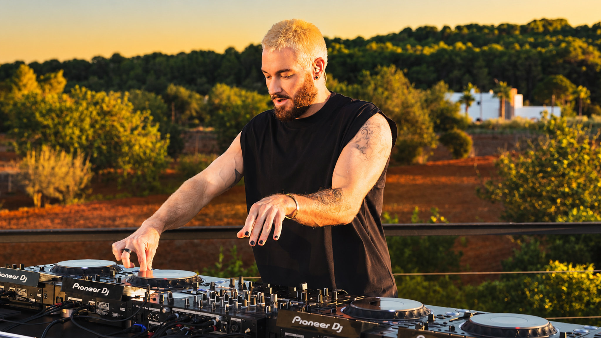 James Hype performing on several Pioneer DJ decks during an outdoor set