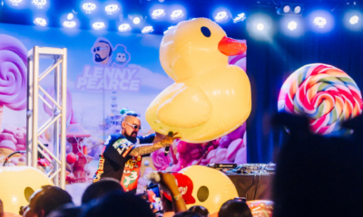Lenny Pearce performing at a baby rave with a giant inflatable duck, colorful stage decorations and families watching from the crowd