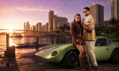GTA VI promotional image showing two characters beside a green sports car at sunset in Vice City