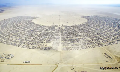 Aerial view of Black Rock City in Nevada’s Black Rock Desert, showing the large semicircular layout of Burning Man and its surrounding camps.