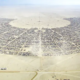 Aerial view of Black Rock City in Nevada’s Black Rock Desert, showing the large semicircular layout of Burning Man and its surrounding camps.