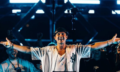 John Summit performing on stage at Experts Only festival with both arms raised during a live festival set