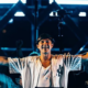 John Summit performing on stage at Experts Only festival with both arms raised during a live festival set