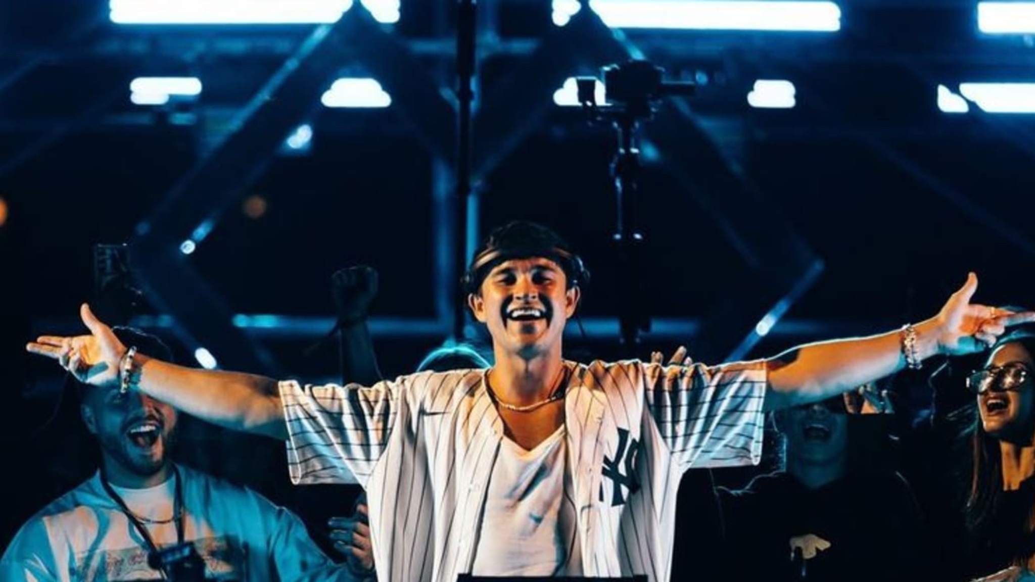 John Summit performing on stage at Experts Only festival with both arms raised during a live festival set