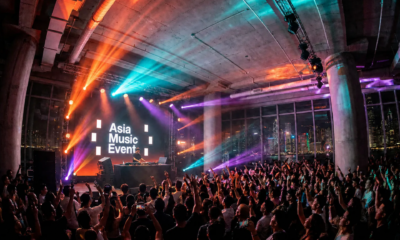 A DJ performs at Asia Music Event in Hong Kong as a large crowd gathers in front of the stage with the Asia Music Event logo on screen.