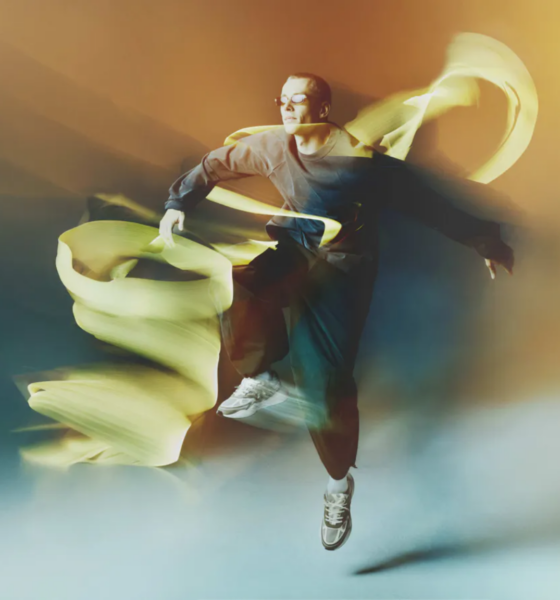 Lost Frequencies wearing Tomorrowland WR1 sneakers in the official campaign, surrounded by flowing yellow fabric.