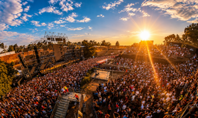 A large crowd gathers in front of a stage at EXIT Festival in Serbia during a sunset performance.