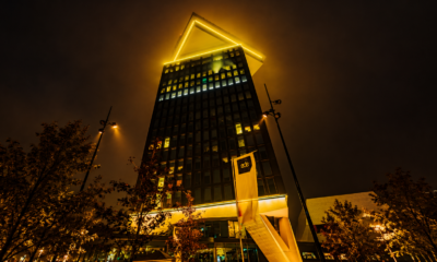 Amsterdam Dance Event branding illuminated in golden light on a high-rise building at night.