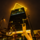 Amsterdam Dance Event branding illuminated in golden light on a high-rise building at night.