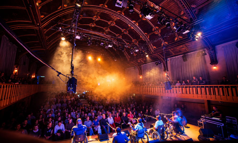 Audience watching a live performance inside an atmospheric historic music venue.