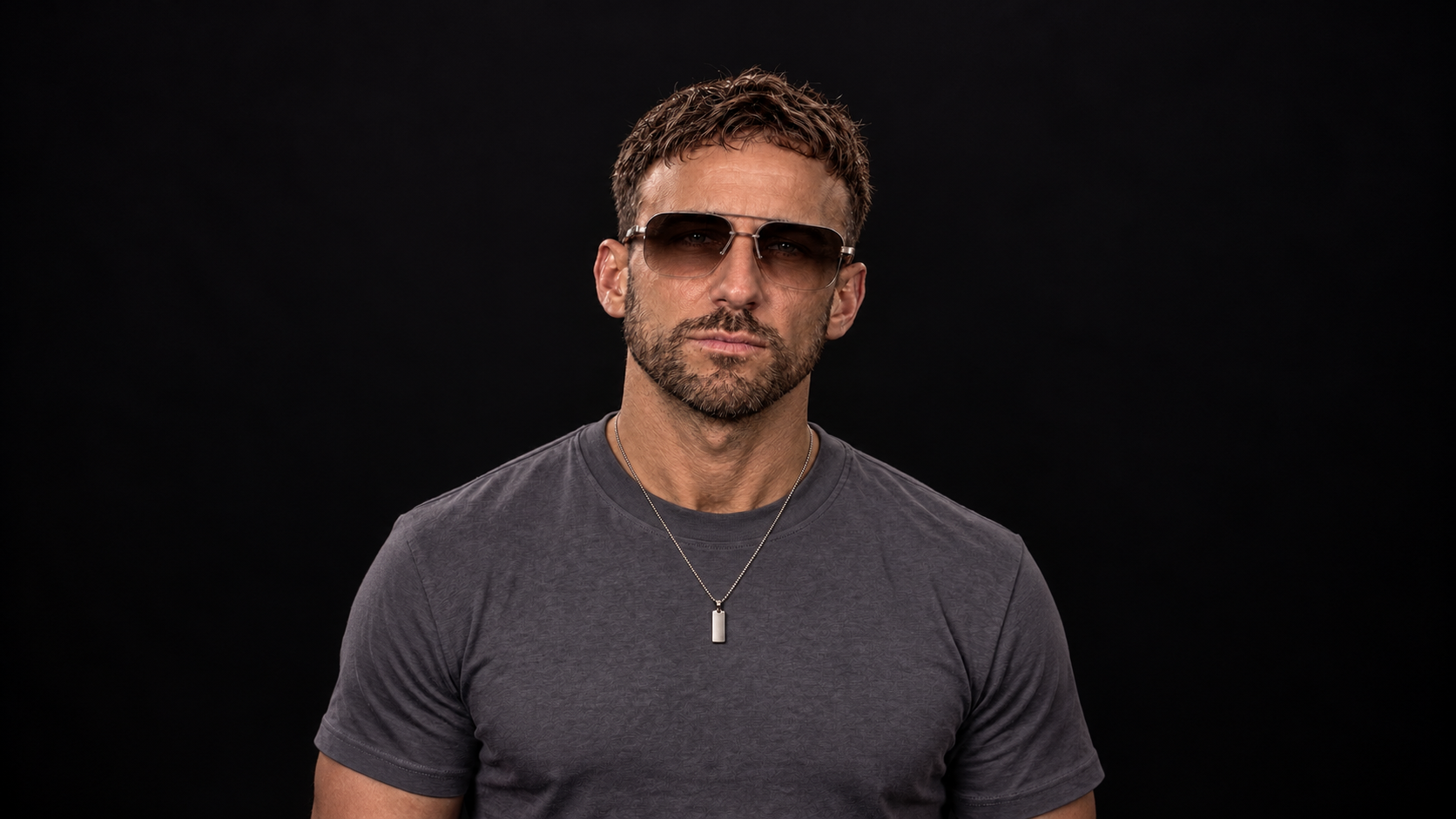 Promotional portrait of Two Phased producer Stephen wearing sunglasses against a dark background.