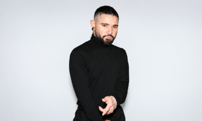 Skrillex wearing a black turtleneck in a studio portrait.