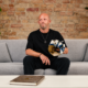 High-Tech Minimal DJ Boris Brejcha sits on a sofa holding his distinctive Joker mask during an announcement about his retirement and final tour.