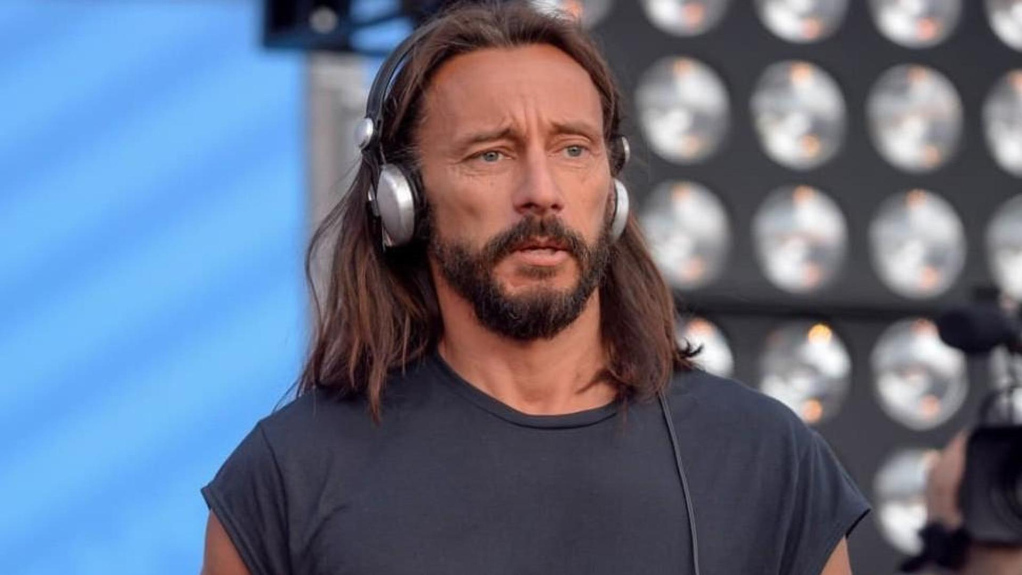 Bob Sinclair wearing silver headphones during a live performance