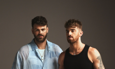 Promotional portrait for The Chainsmokers showing Alex and Drew posing against a dark studio background
