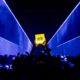 Crowd at Amsterdam Dance Event holding an illuminated ADE sign during a live electronic music event