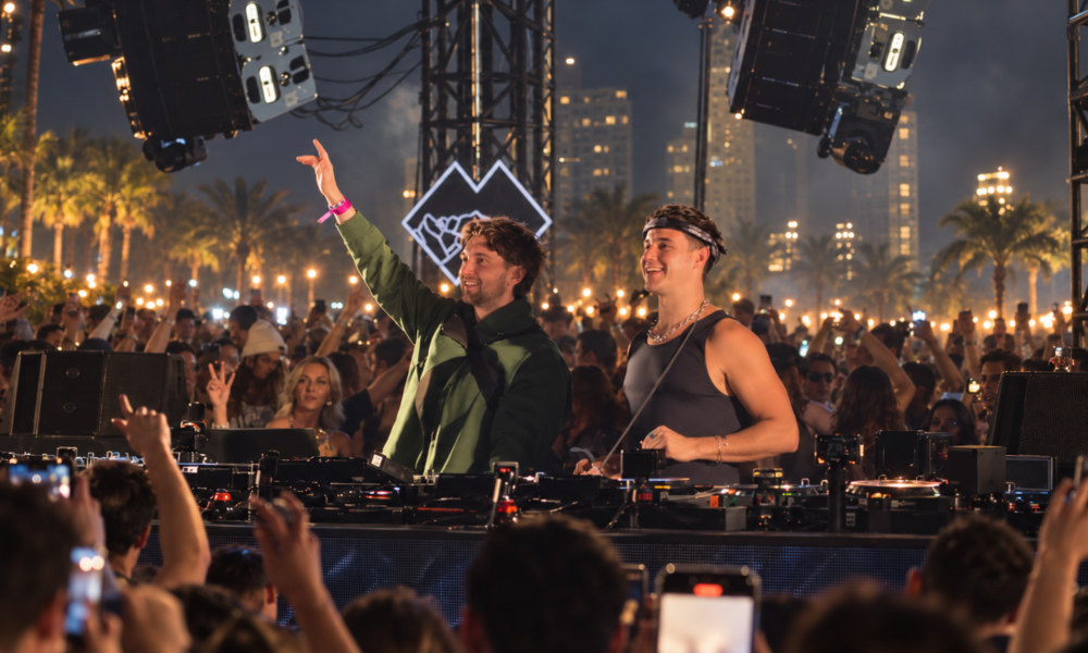 John Summit and Max Styler performing together behind the decks in front of a large outdoor crowd
