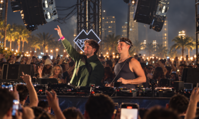 John Summit and Max Styler performing together behind the decks in front of a large outdoor crowd