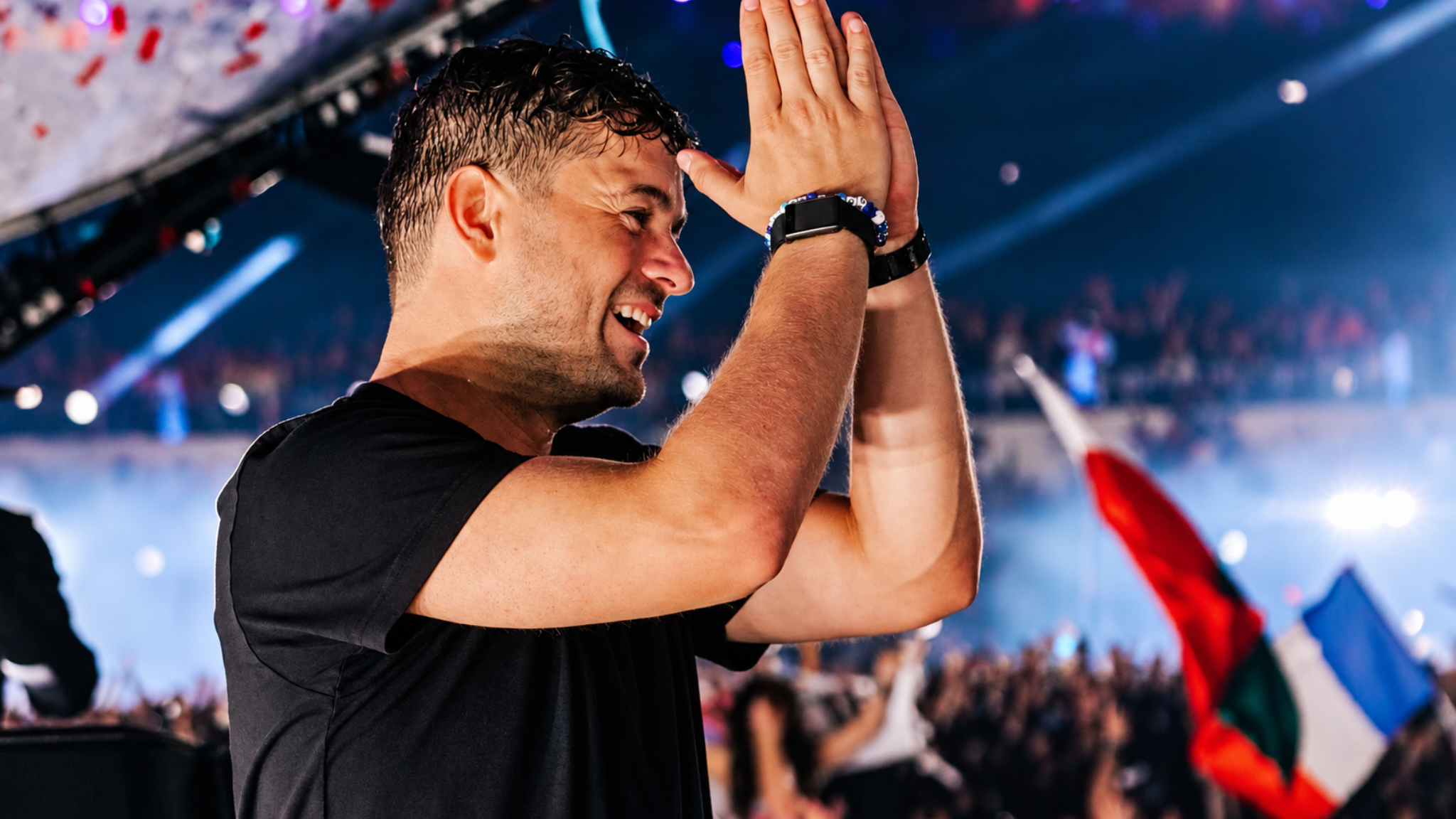 Martin Garrix clapping onstage during a live festival performance