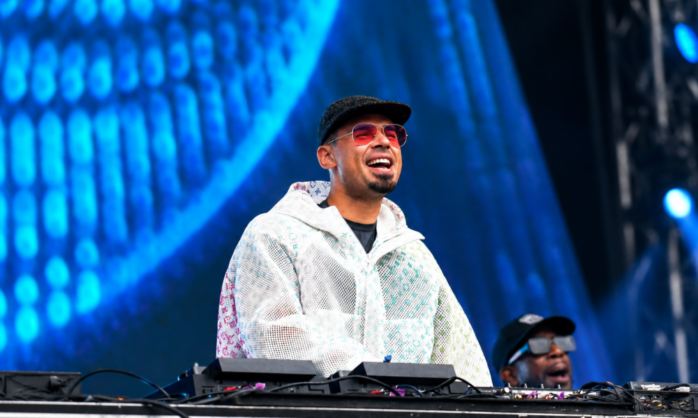 Afrojack smiling behind the DJ decks during a live festival performance
