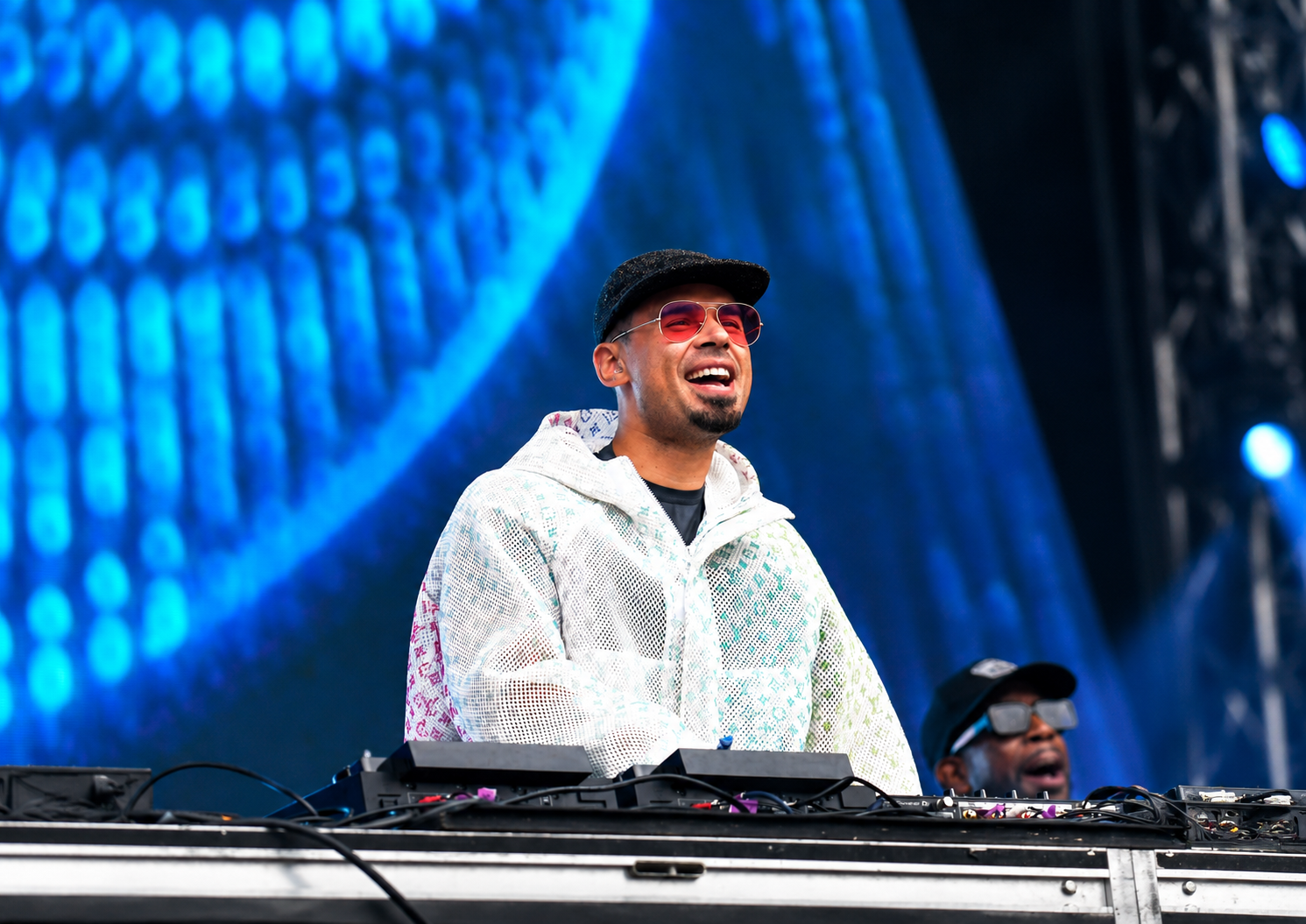 Afrojack smiling behind the DJ decks during a live festival performance