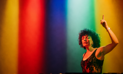 Annie Mac performing on stage under red, blue, green and yellow lighting