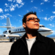 ATB standing in front of a private jet for the 28th anniversary of his trance classic 9 PM