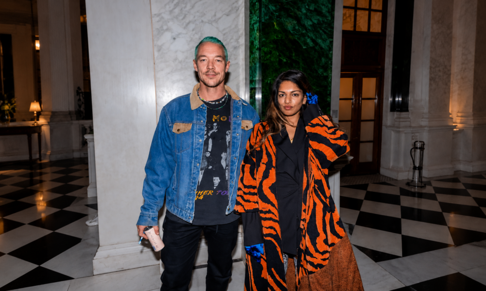 M.I.A. and Diplo posing together indoors at an event.