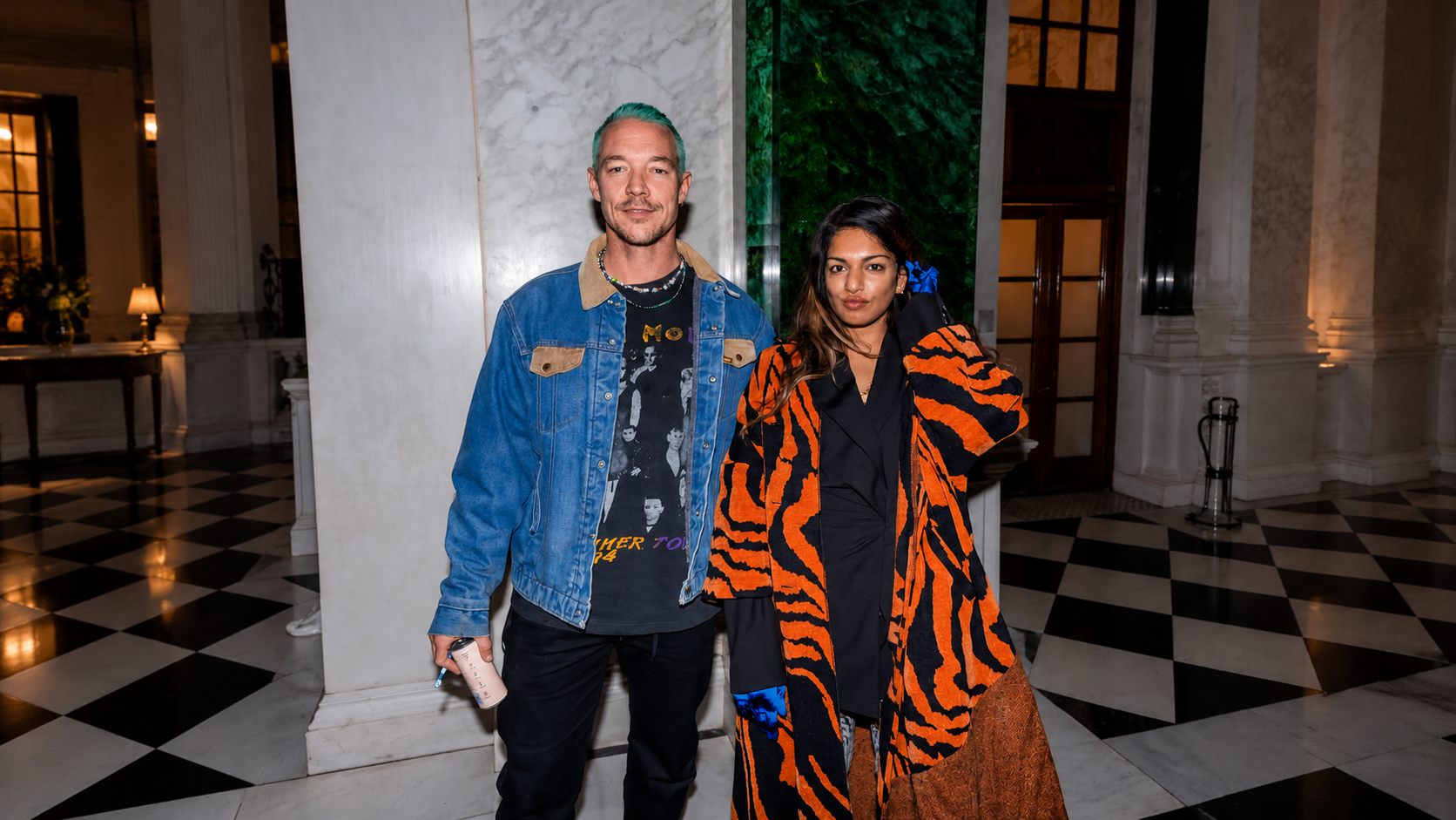 M.I.A. and Diplo posing together indoors at an event.