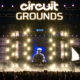 Crowd facing the circuitGROUNDS stage with large LED screens and bright lighting at EDC