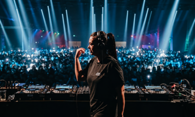 Hannah Laing performing behind the decks in front of a large crowd during a live electronic dance music show