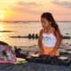 DJ ILLU using a Pioneer DJ controller beside the ocean at sunset