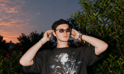 Mau P wearing sunglasses and a black cap outdoors at sunset