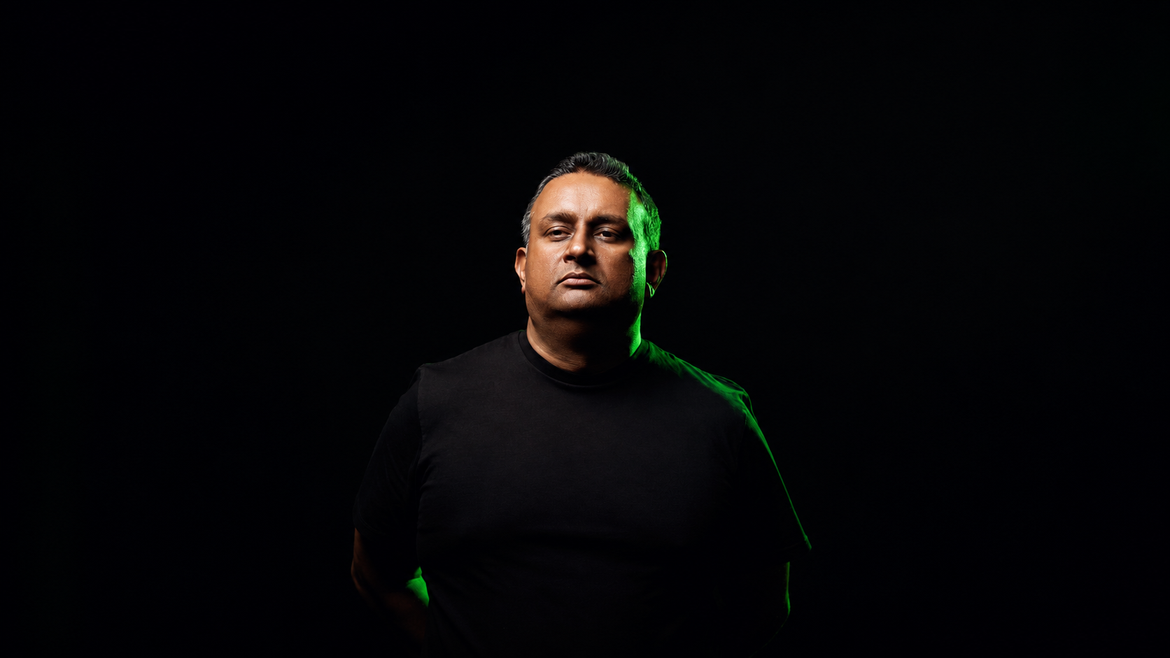 Midnight Evolution wearing a black shirt against a dark background for his new single Meridian on Interplay Flow