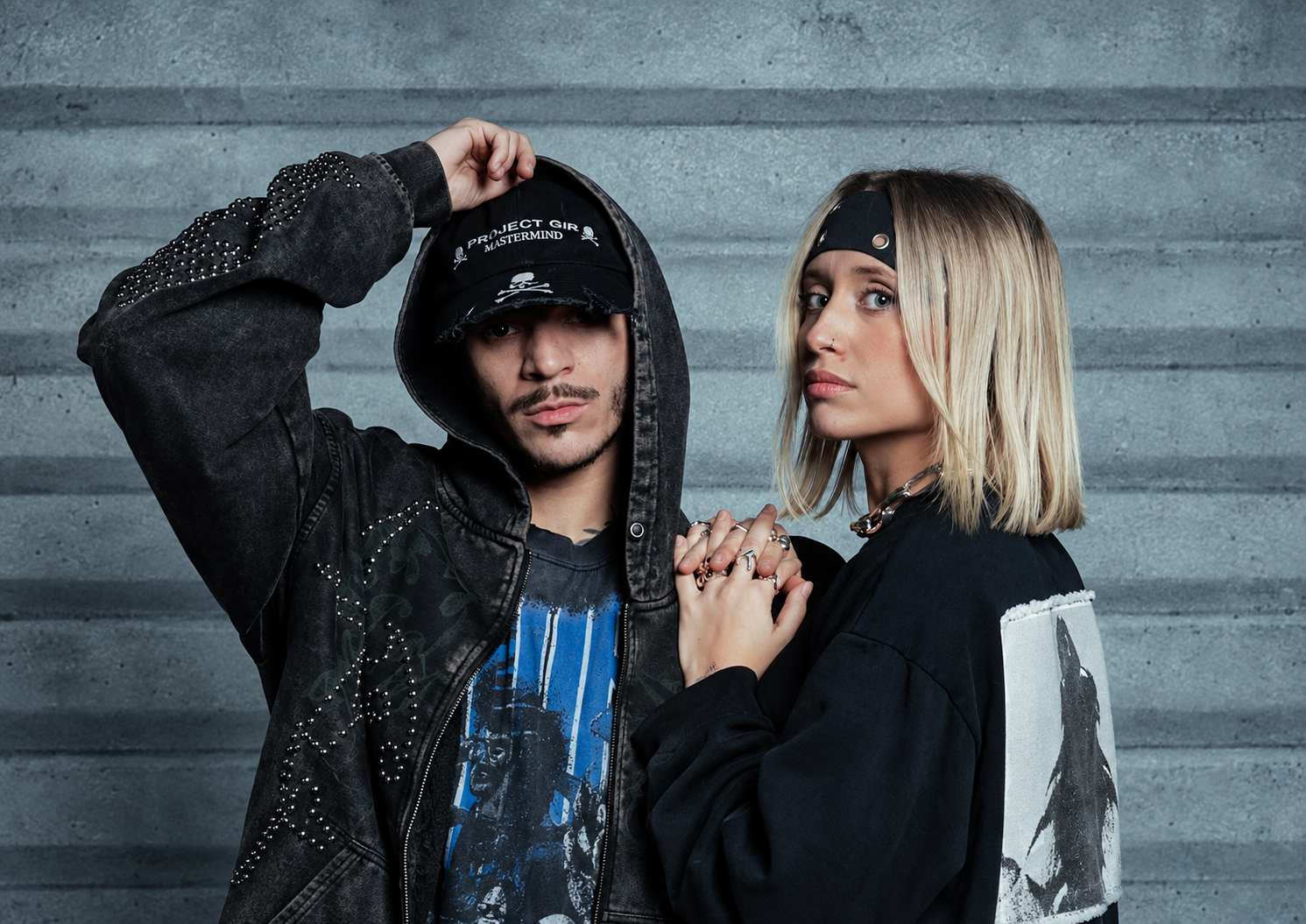 Nico Moreno and Novah posing together in black outfits against a concrete wall