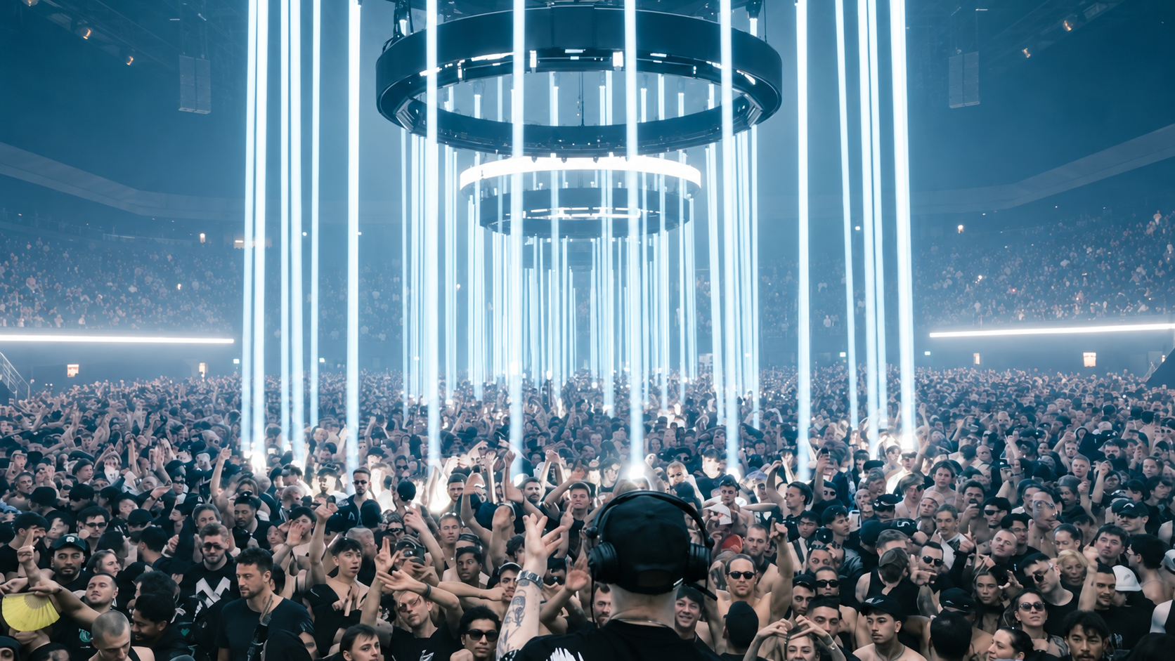 Klangkuenstler performing to a large crowd at an OUTWORLD show beneath vertical white light installations.