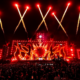 Sunburn Festival stage glowing red as fireworks launch above a large nighttime crowd.