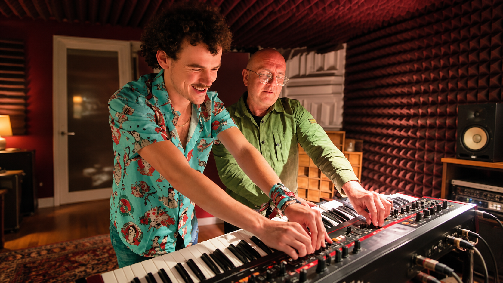 Woody Cook and Zed Bias working together on a synthesizer inside a recording studio